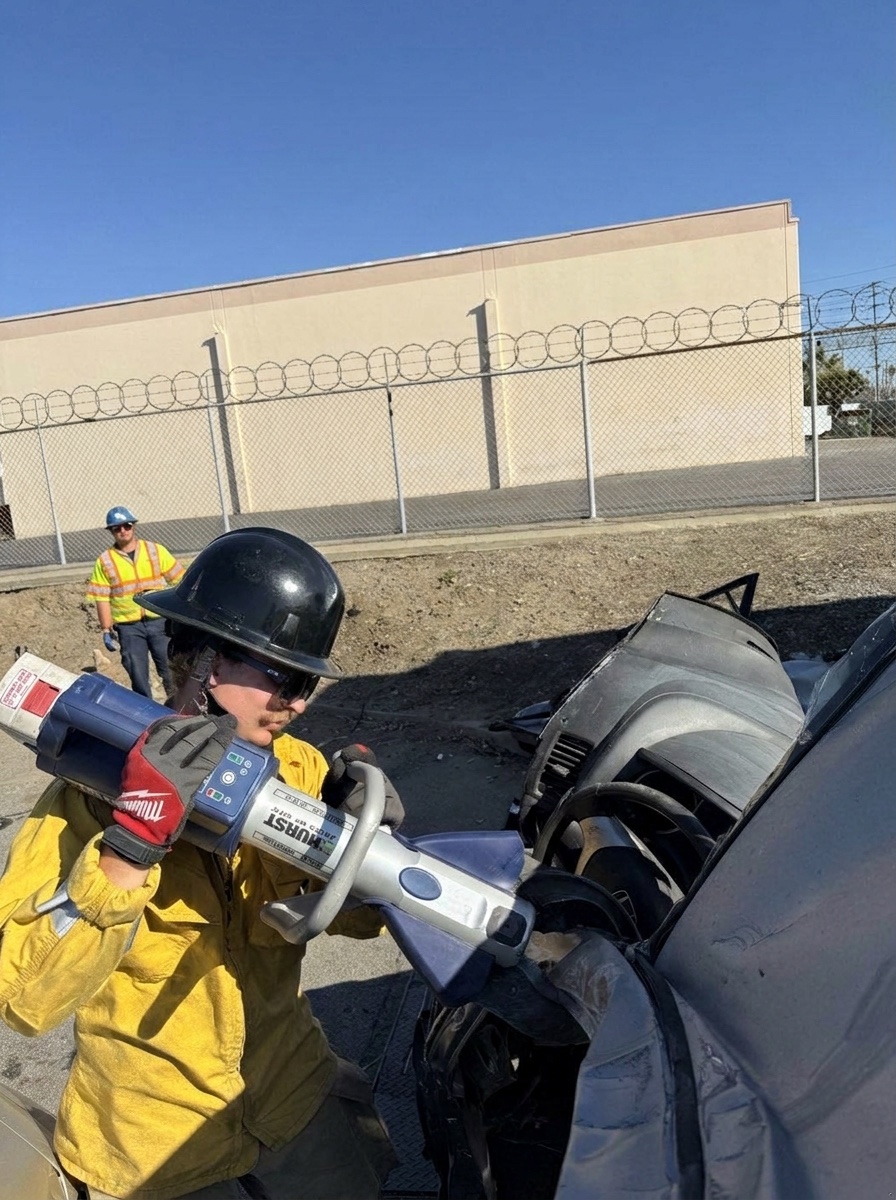 Firefighter cutting a vehicle with hydraulic tools