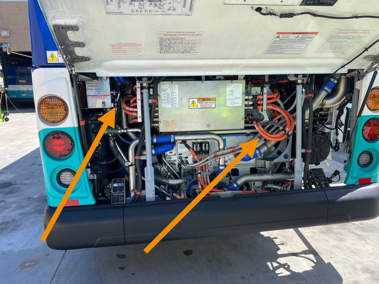 Annotated high-voltage components in an electric bus engine bay